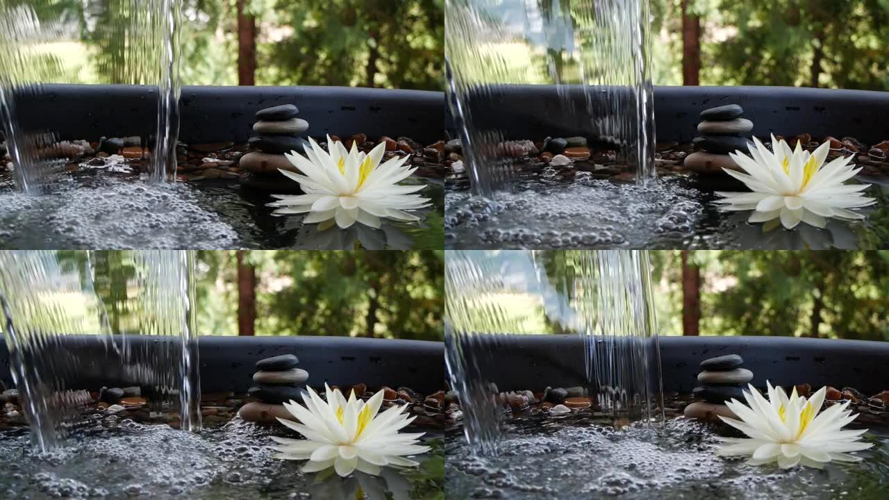 水落在平衡石和白色水合花附近的慢动作