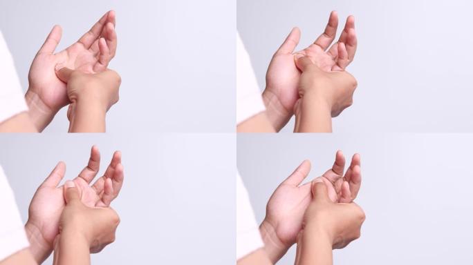 关闭年轻的亚洲妇女痛苦的手周围的手指关节，并用拇指按摩，锻炼，治疗她的痛苦。办公室综合症，神经病变，