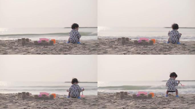 小男孩在沙滩上玩沙子和快乐。