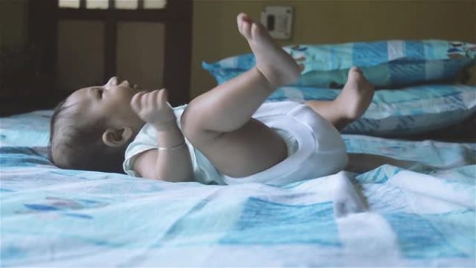 新生男婴用手臂胸部和背部肌肉踢和向后移动抬起头和胸部。四个月大的可爱的幼儿。印度种族。儿童保健背景。
