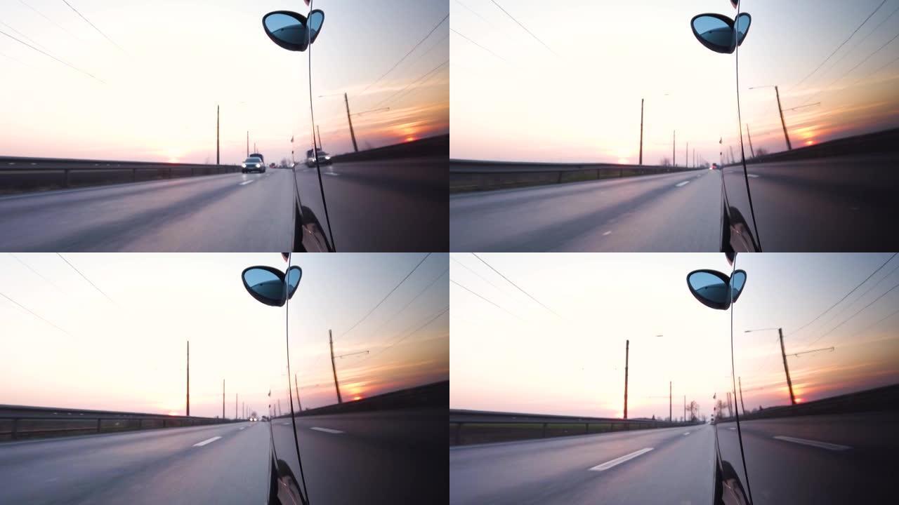 普通汽车在高速公路日落时驾驶POV，迎面而来的交通反映在车身上。从外部4k实时没有人的左侧观点