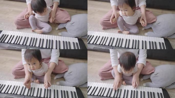 年轻的成年妈妈教女儿弹奏基本的钢琴，方法是将孩子的手放在妈妈的腿上，用电子琴弹奏，幼儿育儿，用乐器弹