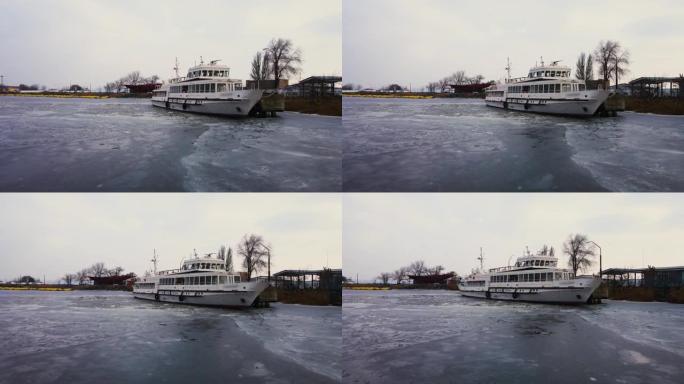 将小型客船停泊在冷冻水中的冰层中