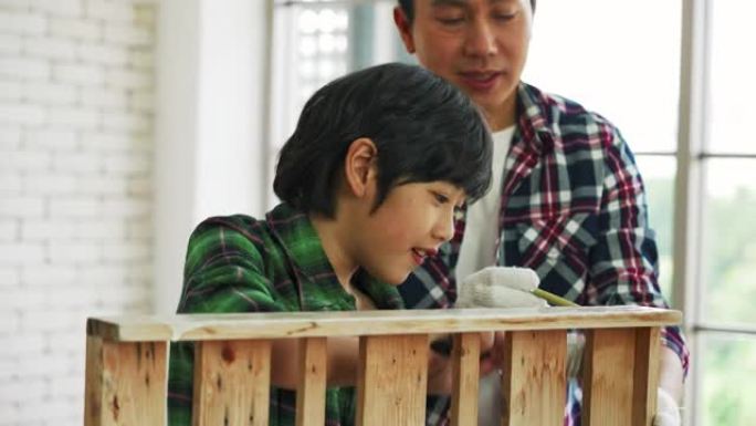 亚洲男人和儿子正在帮助组装房子里的橱柜。