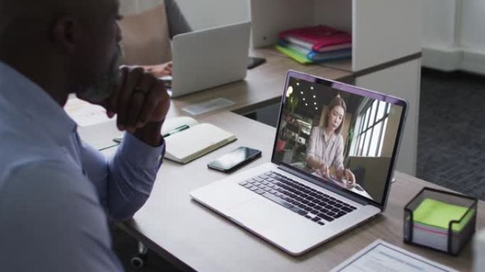 非裔美国高级男子在办公室的笔记本电脑上与女同事进行视频通话