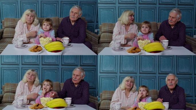 爷爷奶奶在家和孙女一起在电视电视上看动画片电影开心笑