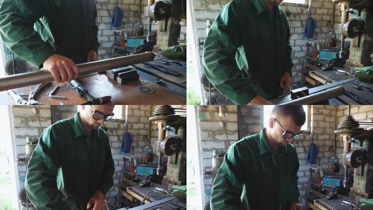 年轻的修理工戴着防护眼镜，将管道固定在桌子上，以在车库进行焊接。穿着制服的男机械师准备在车间焊接金属
