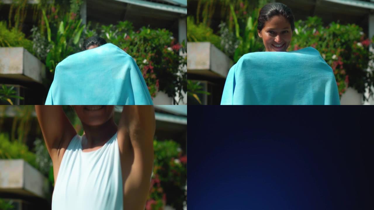 年轻的欧洲黑发女孩在后院用绿色花园擦拭毛巾