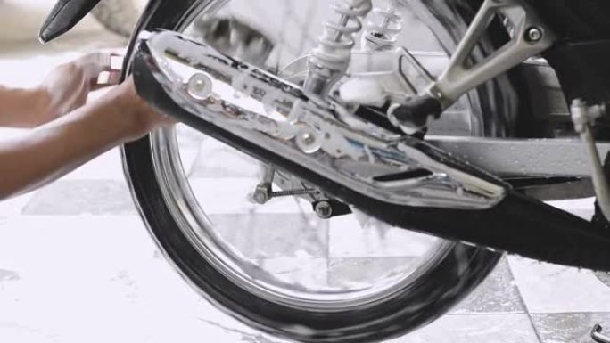 一名男子洗手摩托车后轮的特写镜头