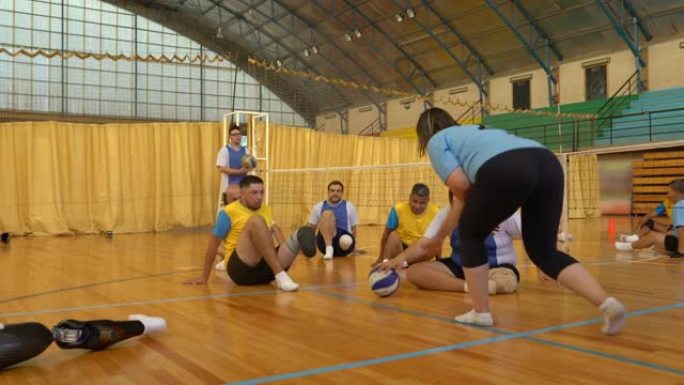 女教练在排球训练中召集球员提供一些指导，室内场地训练凌空抽射