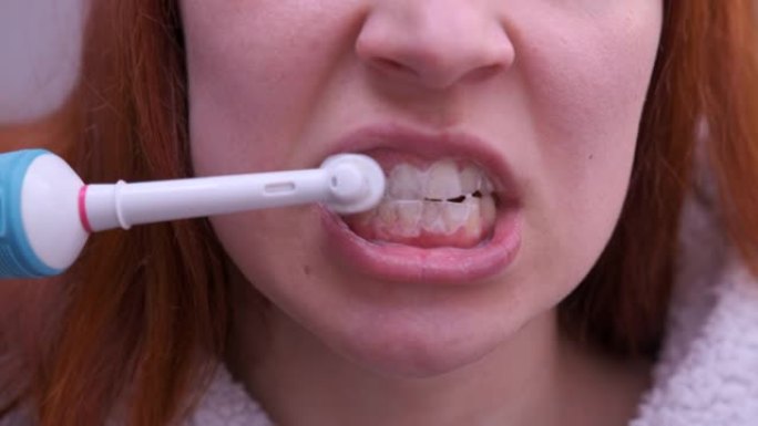 关闭年轻女子用电动牙刷刷牙
