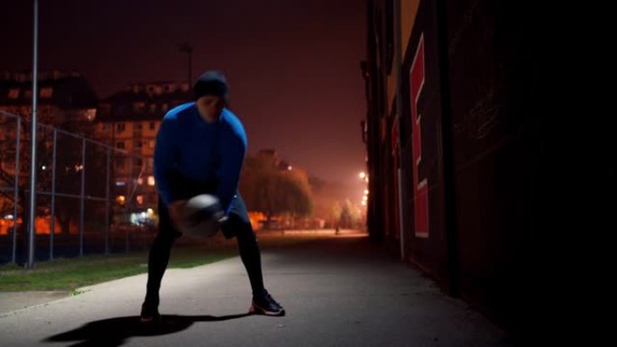 年轻运动员晚上在户外用药球训练
