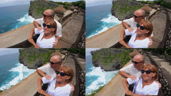 中年高加索夫妇从悬崖顶上欣赏壮丽的海景
