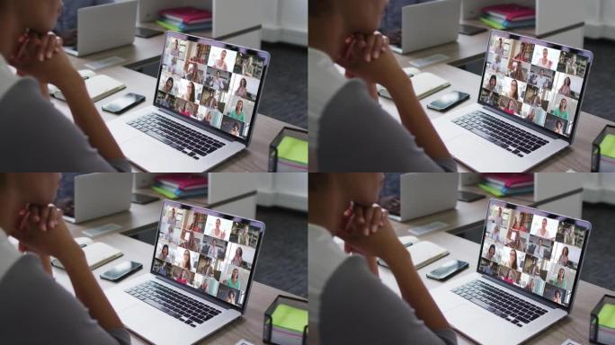 非裔美国妇女与办公室同事在笔记本电脑上进行视频会议