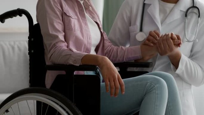 医生在室内轮椅上支持无法识别的残疾女孩，裁剪