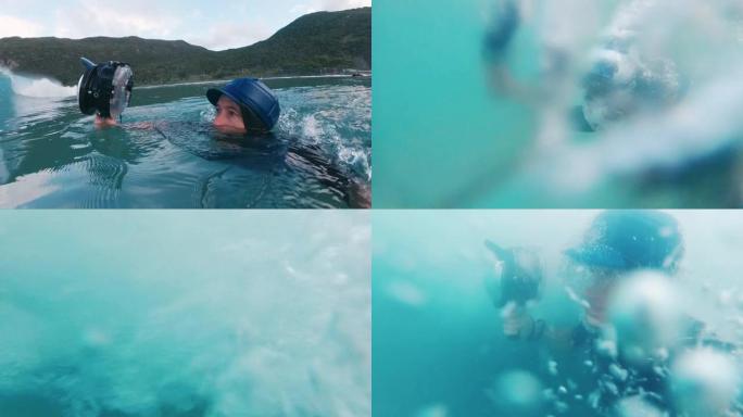 冲浪摄影师。带有动作相机的人拍摄了破浪的照片，然后潜入水下通过