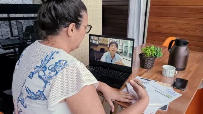 成熟的女人在家与她的财务规划师一起观看视频通话