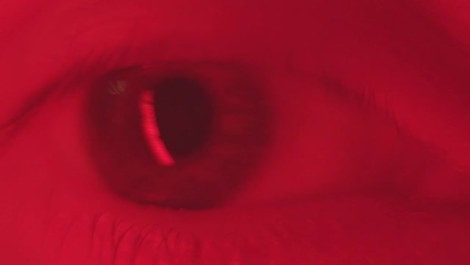 眼睛体操微距镜头。人类进行眼球运动以增强眼部肌肉并改善视力。男性灰色睁眼看着相机。健康视力概念。红灯