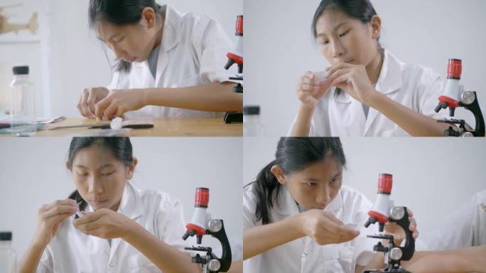 亚洲学童穿着实验服在课堂上与显微镜一起研究，教育生活方式理念。