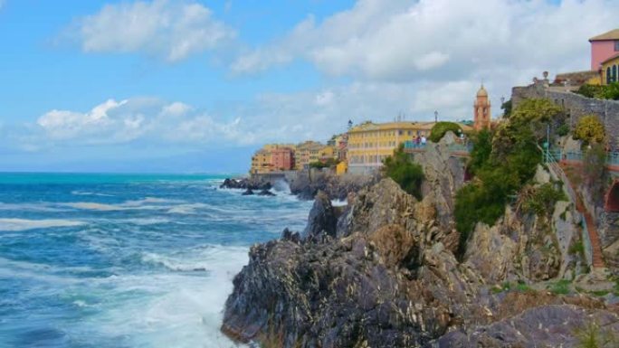 在美丽的晴天，波涛汹涌的海浪在意大利利古里亚里维埃拉热那亚的内尔维小港口坠毁