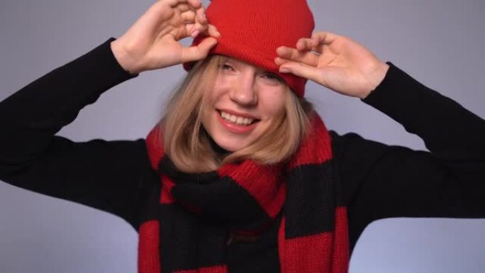 金发有趣的年轻女性上下拉红色帽子