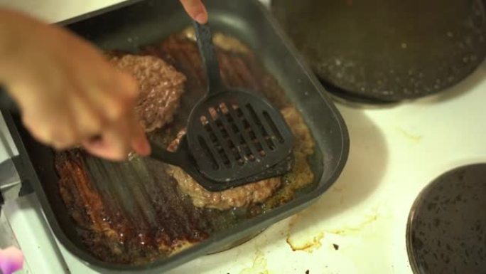 汉堡肉饼在炉子上的烤盘中油炸。