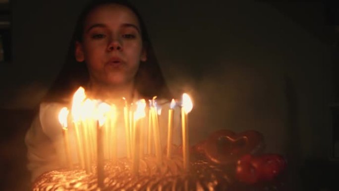 迷人的女孩吹灭生日蛋糕上的蜡烛