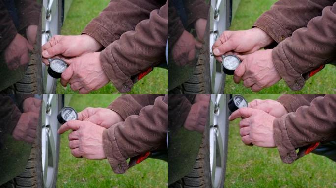 机械师使用压力表检查轮胎压力。用于汽车轮胎压力测量的Mans手持轮胎压力计机。用轮胎压力表标准检查压