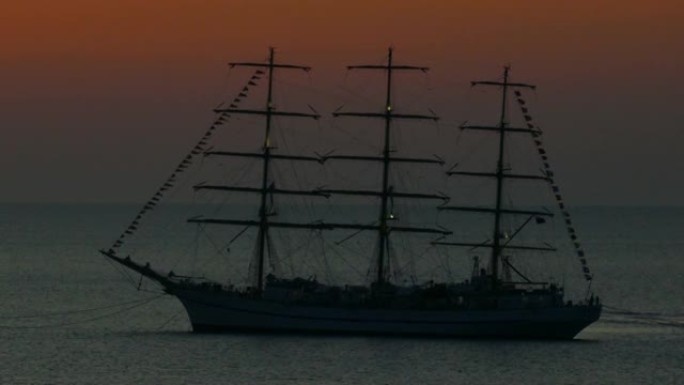 海上日落时一艘旧帆船的剪影
