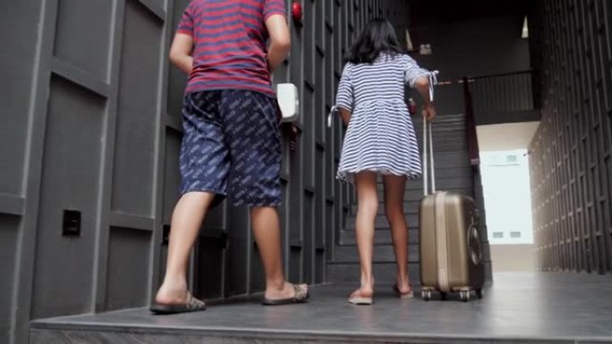 入住后，快乐的亚洲男孩和女孩在台阶上背着行李到酒店的房间，暑假生活方式理念。