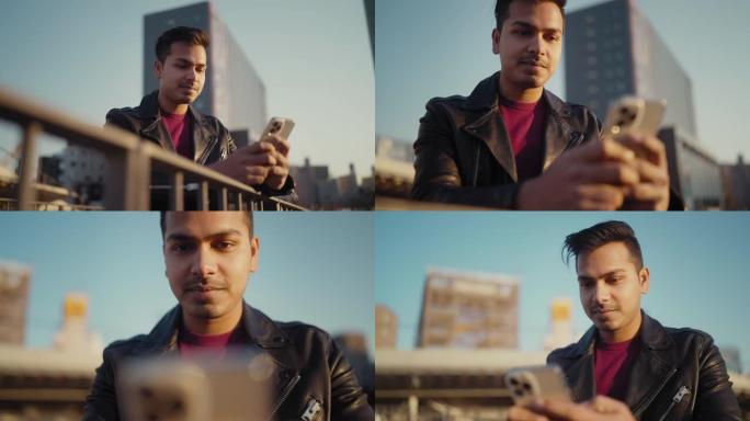 年轻帅气的印度男人在城市里使用智能手机
