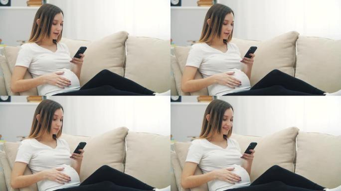 4k慢动作孕妇微笑发短信的视频。