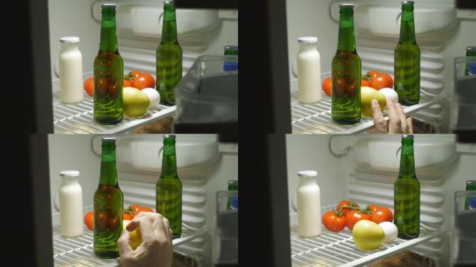 一个人的手在晚上打开冰箱，感觉到瓶子里的啤酒。他喝啤酒，站不起来。醉酒和酒精依赖