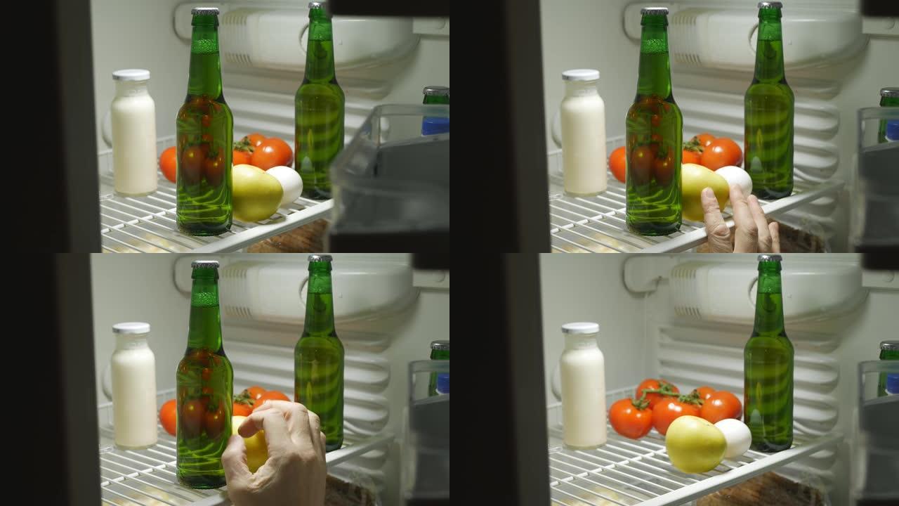一个人的手在晚上打开冰箱，感觉到瓶子里的啤酒。他喝啤酒，站不起来。醉酒和酒精依赖