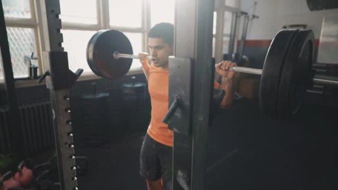一名运动男子在健身房举重