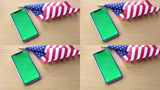 美国国旗躺在桌子上与手机色度键模拟屏幕