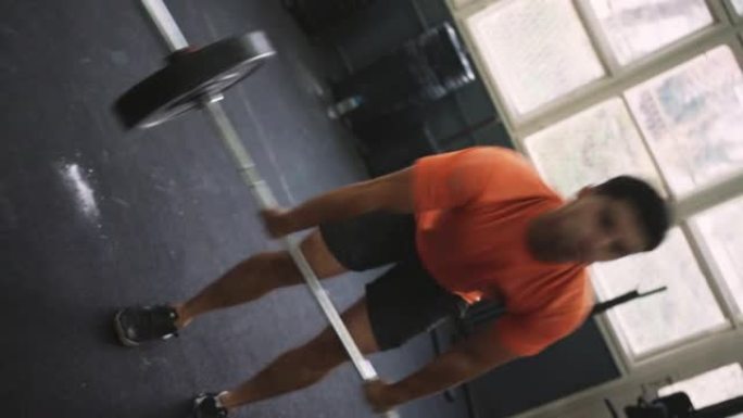 运动男子在健身房用杠铃和举重训练