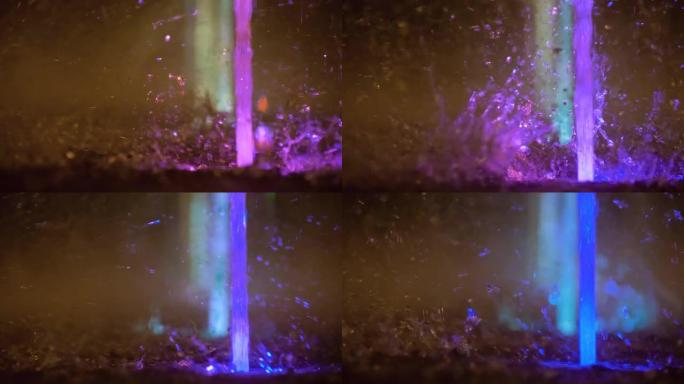 五颜六色的喷泉飞溅。以各种颜色照亮的水的慢动作落在喷泉上，该喷泉在夜间改变了其水色。