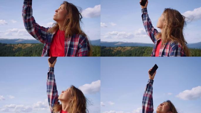 女人在山上捕捉移动信号。女孩用智能手机在空中跳跃