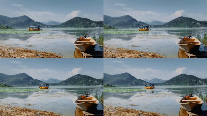 黑山的斯卡达尔湖景，远处有一艘流动的渡轮，岸边有一艘船。