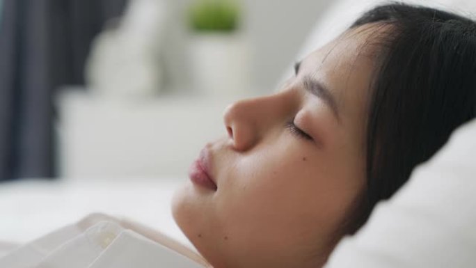 脸上的亚洲女人在床上睡个好觉。