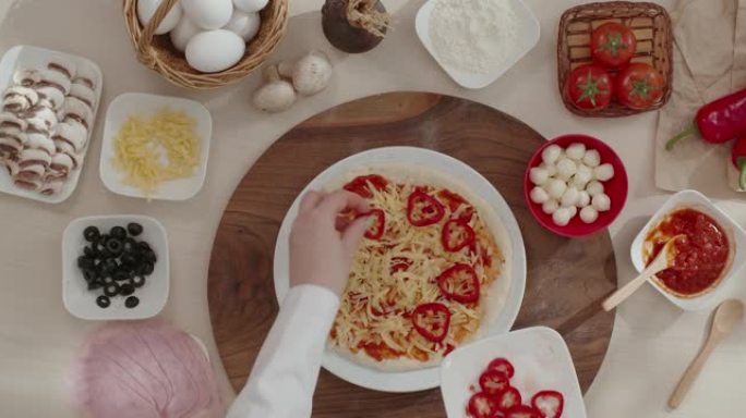 女人通过在线烹饪课程的食谱用火腿烹饪意大利披萨。关于如何制作美味披萨的分步说明。