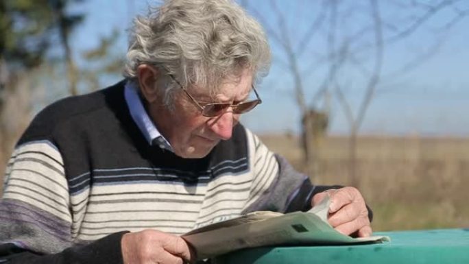 一位戴眼镜的老人看报纸