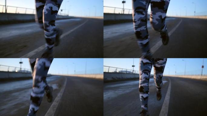 穿着迷彩绑腿的女性腿的特写镜头沿着道路奔跑。