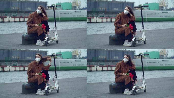 一个戴着防护面具，戴着红花的女人，郁金香在情人的码头上等着，旁边站着一辆踏板车