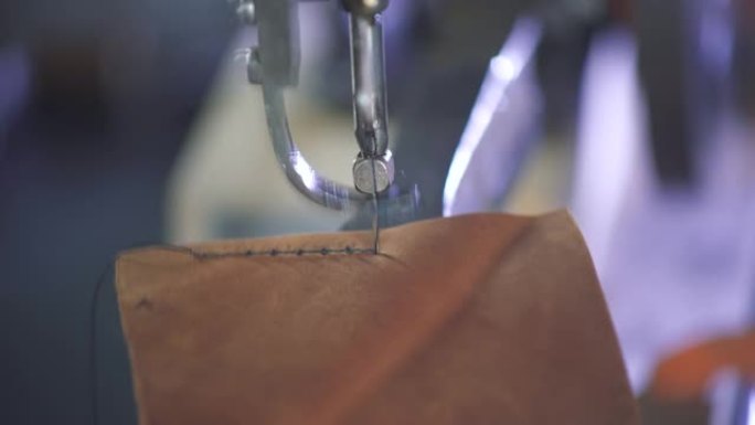 特写缝纫机针在运动。皮革工匠创造了一种工艺DIY产品。车间老板在工作场所工作。服装工厂的裁缝大师。男