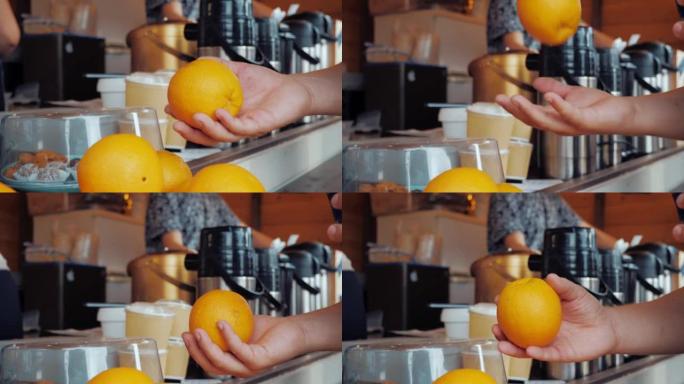 一名男子从咖啡馆柜台拿出一个橘子，然后将其扔向空中。