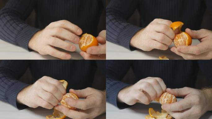 男人的手从皮肤上清洗橘子。一个穿着深色夹克的男人在桌子上剥了一个橘子。多莉拍摄，特写。