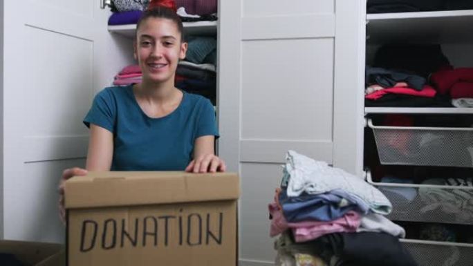 年轻女子整理衣服捐赠