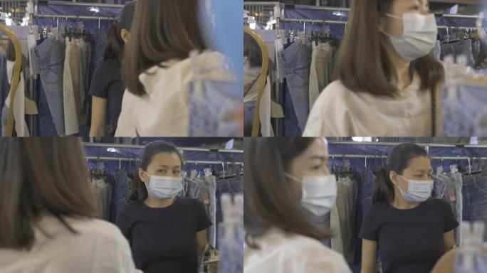 戴着口罩的亚洲夫妇在新型冠状病毒肺炎covid电晕病毒情况下购物一些布